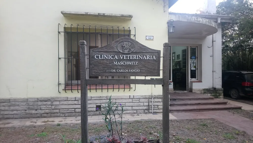 El cartel de madera de la Clínica Veterinaria Maschwitz, en el jardín de la casa